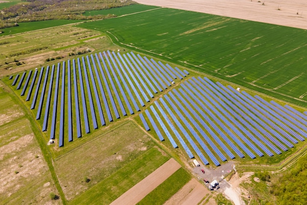 Luchtfoto van grote duurzame elektrische centrale met veel rijen fotovoltaïsche zonnepanelen voor het produceren van schone ecologische elektrische energie. Hernieuwbare elektriciteit met nul-emissieconcept.