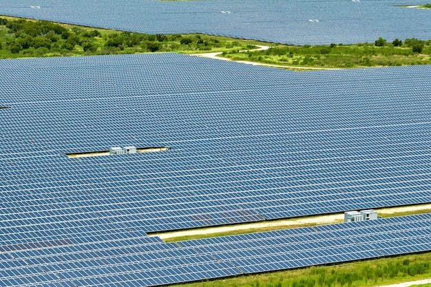 Luchtfoto van grote duurzame elektrische centrale met veel rijen fotovoltaïsche zonnepanelen voor het produceren van schone elektrische energie hernieuwbare elektriciteit zonder emissieconcept