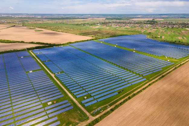 Luchtfoto van grote duurzame elektrische centrale met veel rijen fotovoltaïsche zonnepanelen