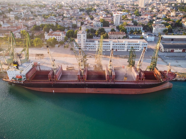 Luchtfoto van grote vrachtschip bulkcarrier is geladen met graankorrel in de haven bij zonsondergang