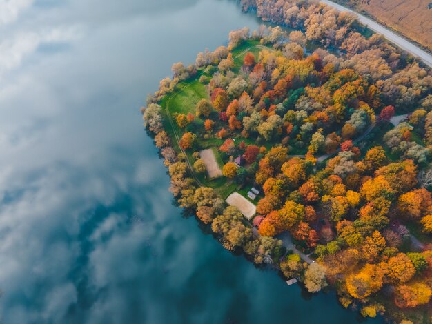 Luchtfoto van herfstbos met meerhemel weerspiegeld in waterkopieerruimte