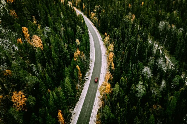 Luchtfoto van herfstweg met herfstbossen en eerste sneeuw in Finland