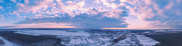 Luchtfoto van het besneeuwde winterlandschap bij zonsondergang Horizontaal panorama