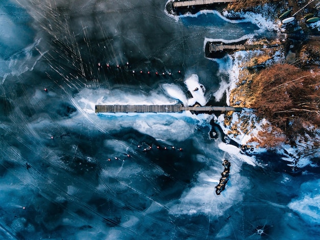 Luchtfoto van het bevroren wintermeer met houten pieren van bovenaf vastgelegd met een drone in Finland
