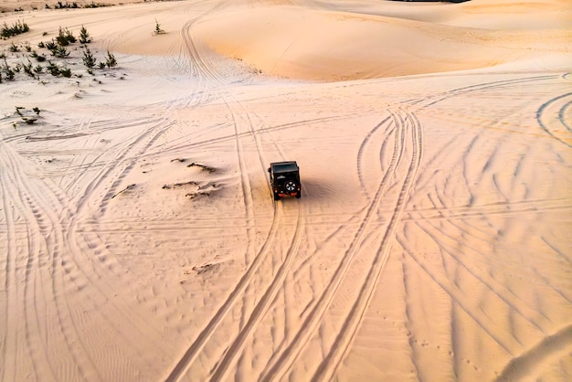 Luchtfoto van het bovenaanzicht van een vliegende drone van een professionele chauffeur die een gevaarlijke rit heeft met de auto in het woestijnlandschap. m151 mutt is een amerikaans leger terreinwagen, geproduceerd van 1959 tot 1982