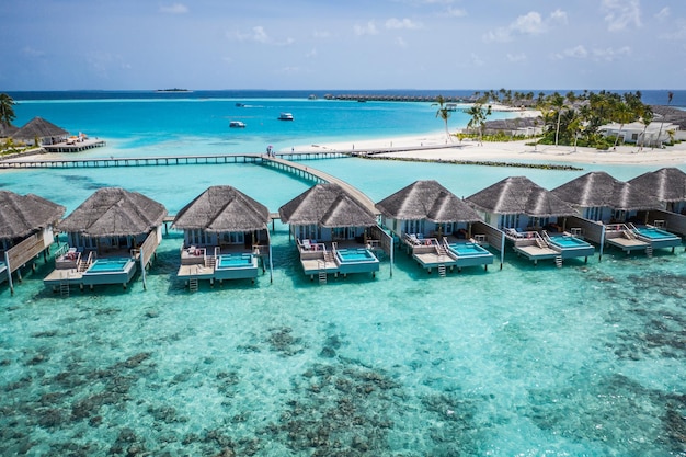 Luchtfoto van het eiland Malediven, luxe watervilla's resort en houten pier. Mooie lucht en oceaan