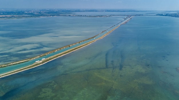 Luchtfoto van het kanaal in de lagune van het water van de Middellandse Zee Etang de Thau van boven, Zuid-Frankrijk