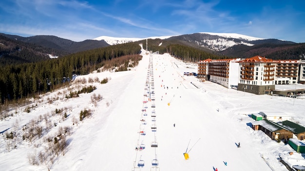 Foto luchtfoto van het skigebied in de bergen in de winter. machines voor het sproeien van kunstsneeuw.