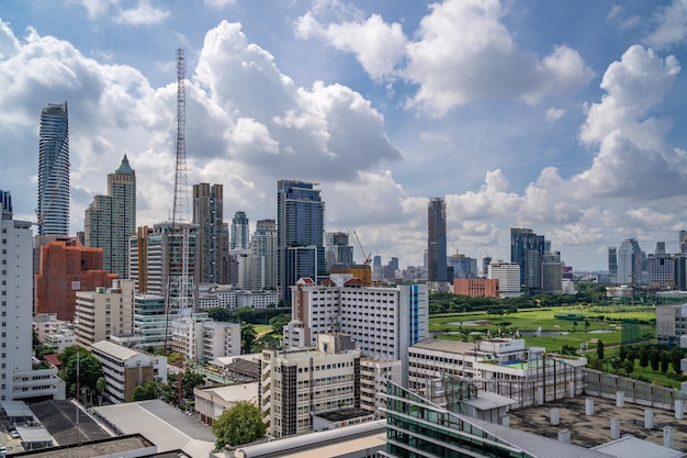 Luchtfoto van het stadsbeeld van bangkok in de ochtend met hoogbouw met een golfbaan en bewolkte hemel