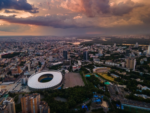 Luchtfoto van het voetbalstadion in de stad tegen de achtergrond van zonsondergang en prachtige wolken