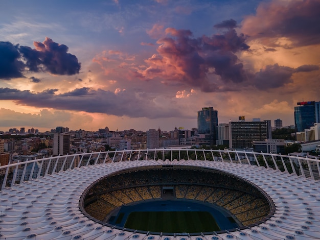 Luchtfoto van het voetbalstadion in de stad tegen de achtergrond van zonsondergang en prachtige wolken