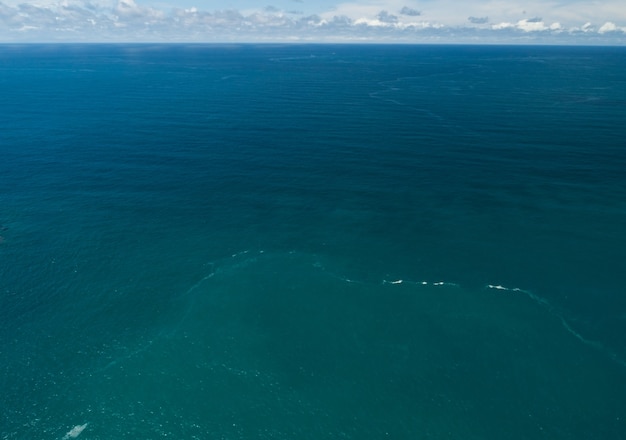 Luchtfoto van het zeeoppervlak, Bird eye view-foto van blauwe golven en de textuur van het wateroppervlak Blauwe zeeachtergrond Prachtige natuur Prachtig uitzicht.