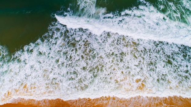 Luchtfoto van het zeeoppervlakBird eye view foto van golven en wateroppervlaktextuurVerbazingwekkende zeegolven die op strandachtergrond brekenPrachtige natuur landschapsmening zee oceaan achtergrond