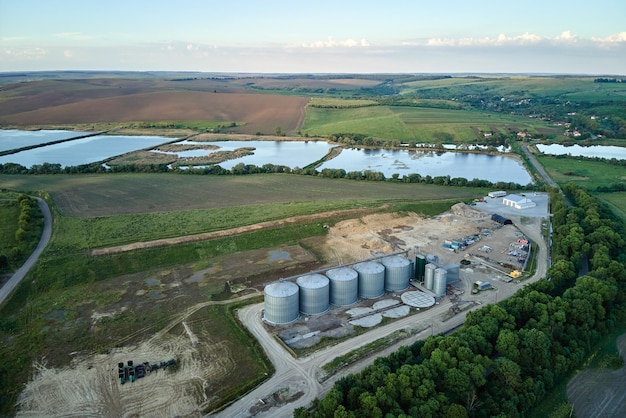 Luchtfoto van industriële geventileerde silo's voor langdurige opslag van graan en oliehoudende zaden metalen lift voor het drogen van tarwe in landbouwzone