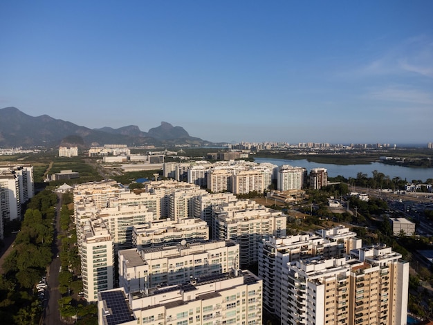 Luchtfoto van jacarepagua in rio de janeiro brazilië residentiële gebouwen en bergen rond het meer barra da tijuca strand op de achtergrond zonnige dag drone foto