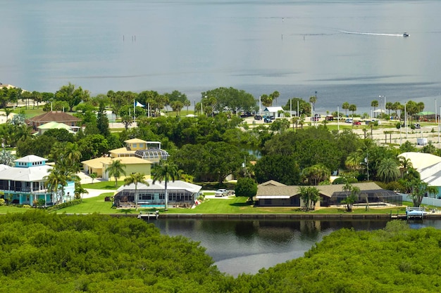 Luchtfoto van landelijke particuliere huizen in afgelegen voorsteden in de buurt van Florida wild wetlands met groene vegetatie aan de kust van de baai Leef dicht bij de natuur concept
