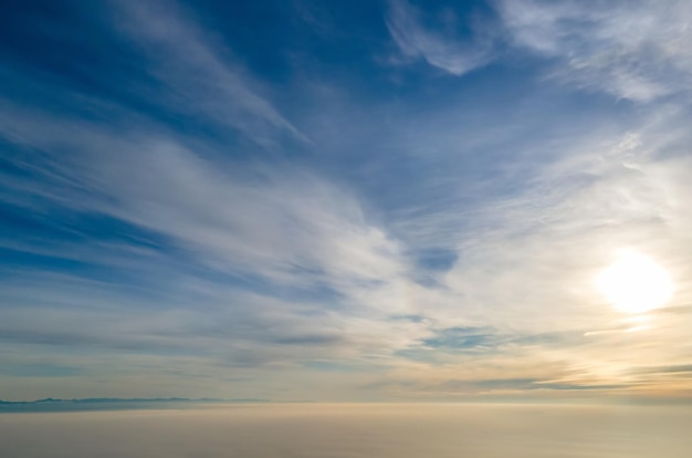 Luchtfoto van levendige gele zonsopgang boven witte dichte wolken met blauwe lucht boven je hoofd.