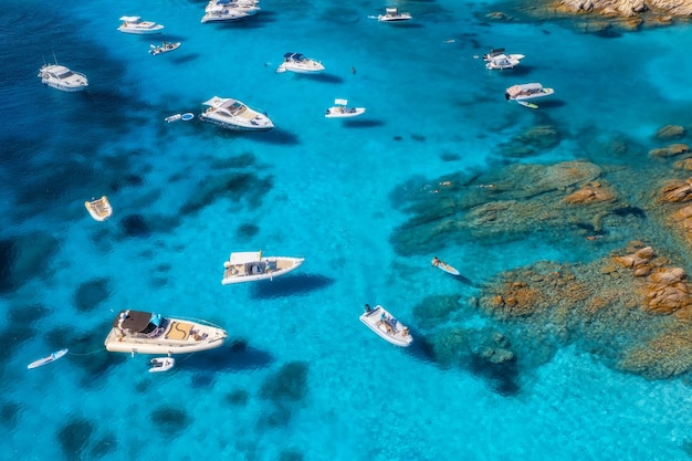 Luchtfoto van luxe jachten en boten op blauwe zee op zonnige zomerdag Reizen in Sardinië Italië Drone-weergave van bovenaf van speedboten jachten zee baai rotsachtige kust transparant water zeegezicht