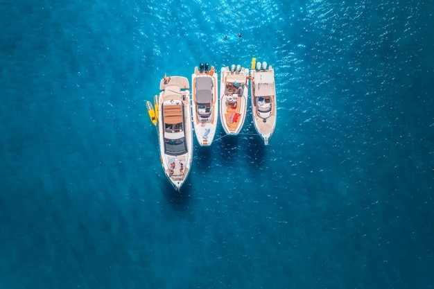 Luchtfoto van luxe jachten en boten op de blauwe zee bij zonsondergang in de zomer Reizen in Sardinië Italië Drone-weergave van bovenaf van speedboten jachten zee lagune transparant turkoois water zeegezicht