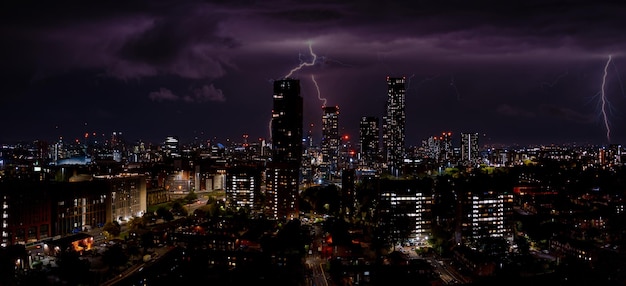Luchtfoto van Manchester, Verenigd Koninkrijk 's nachts. Nachtwolkenkrabbers die zich in de stadslichten bevinden.