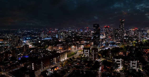 Luchtfoto van Manchester, Verenigd Koninkrijk 's nachts. Nachtwolkenkrabbers die zich in de stadslichten bevinden.