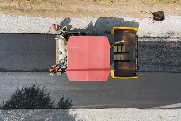 Luchtfoto van nieuwe wegenbouw met machines voor het leggen van asfalt op het werk.