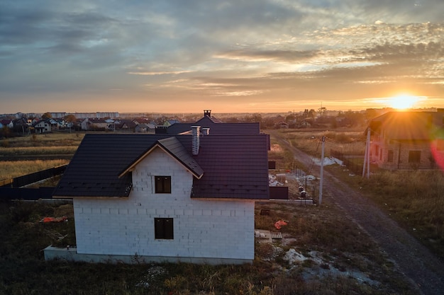 Luchtfoto van onafgewerkt huis met beluchte lichtgewicht betonnen muren en houten dakframe bedekt met metalen tegels in aanbouw