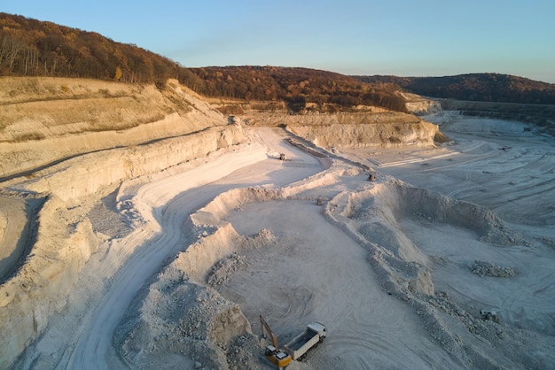 Luchtfoto van open mijn van zandsteenmaterialen voor de bouwsector met graafmachines en dumptrucks Zwaar materieel in de mijnbouw en productie van nuttig mineralenconcept