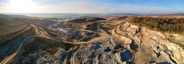 Luchtfoto van open mijn van zandsteenmaterialen voor de bouwsector met graafmachines en dumptrucks Zwaar materieel in de mijnbouw en productie van nuttig mineralenconcept