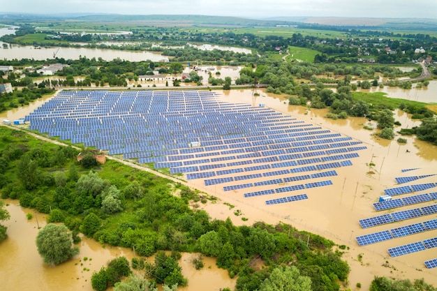 Luchtfoto van overstroomde zonne-energiecentrale met vuil rivierwater in het regenseizoen