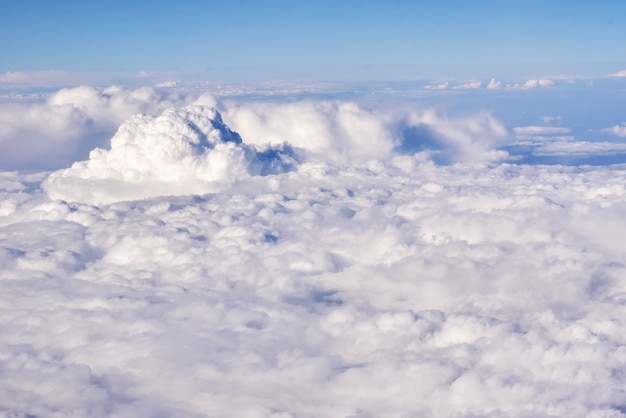 Luchtfoto van pluizige wolken in een stratosfeer vanuit vliegtuig raam