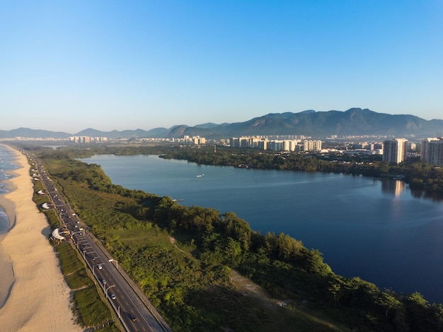 Luchtfoto van reserva strand marapendi lagune en autoverkeer op lucio costa avenue barra da tijuca en recreio in rio de janeiro brazilië zonsopgang zonnige dag drone foto praia da reserva