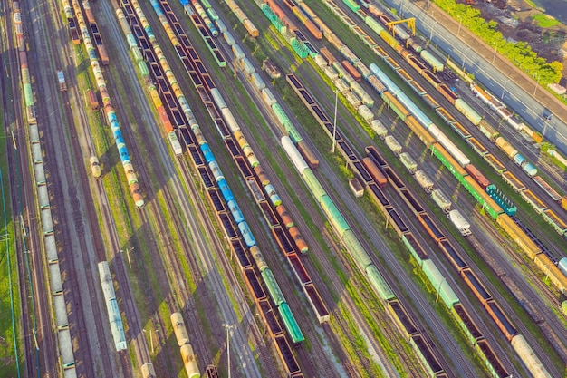 Luchtfoto van spoorsorteervrachtstation met treinwagons met veel spoorlijnen spoorweg Zware industrie landschap op avond zonsonderganglicht