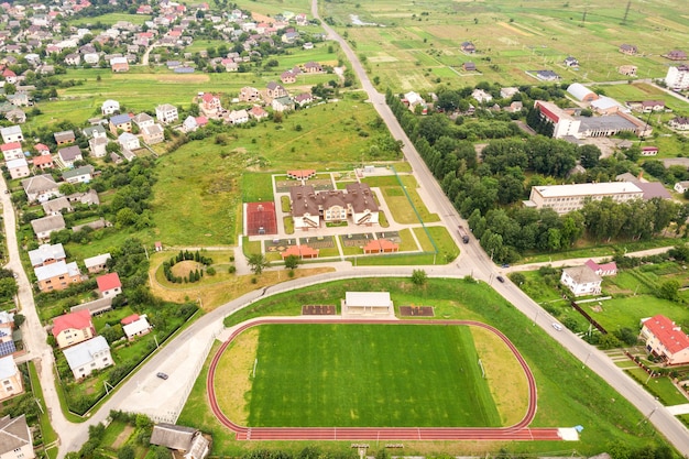 Luchtfoto van sportstadion met rode atletiekbanen en groen gras voetbalveld