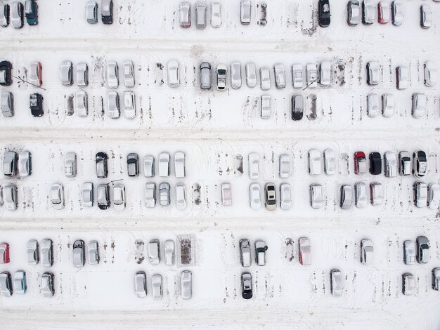 Luchtfoto van stedelijke parkeerplaats bedekt met verse sneeuw in de winter.