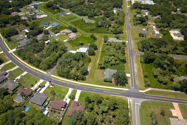 Foto luchtfoto van straatverkeer met rijdende auto's in een kleine amerikaanse buitenwijk van de stad met privéwoningen tussen groene palmbomen in een rustige woonwijk in florida