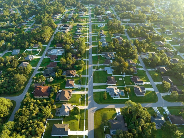 Luchtfoto van straatverkeer met rijdende auto's in een kleine Amerikaanse buitenwijk van de stad met privéwoningen tussen groene palmbomen in een rustige woonwijk in Florida