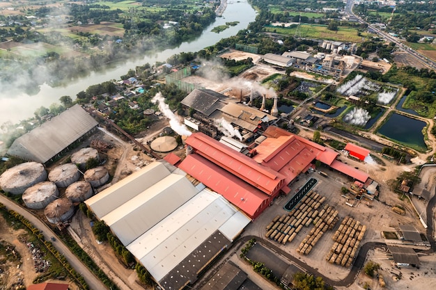 Luchtfoto van suikerbio-ethanol vertaalfabriek die werkt met stoom uit de schoorsteen en suikerrietwagen