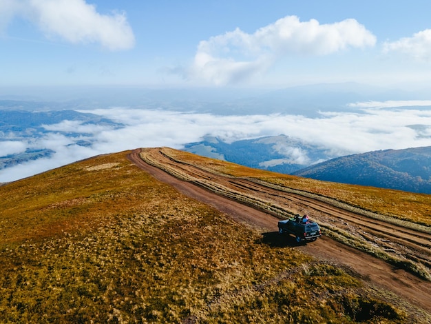 Luchtfoto van suv off-road reizen klimmen door bergheuvel