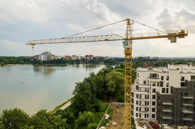 Luchtfoto van torenhijskraan en betonnen frame van hoog appartementsgebouw in aanbouw in een stad Stedelijke ontwikkeling en vastgoedgroeiconcept