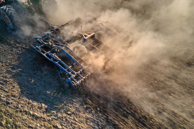 Luchtfoto van tractor die landbouwgrond ploegt en grond voorbereidt voor zaaien in de zomer