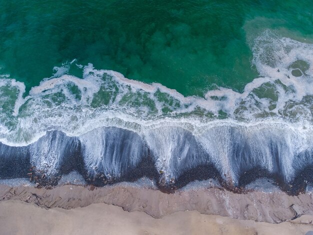 Luchtfoto van turquoise golven die de kust bereiken