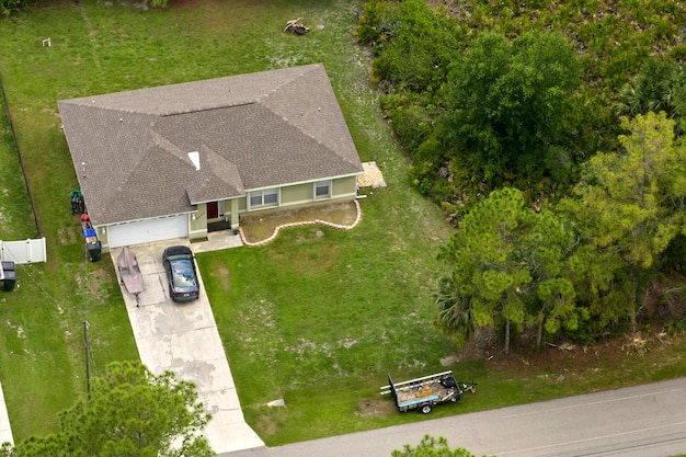 Luchtfoto van typisch eigentijds Amerikaans privéhuis met dak bedekt met asfaltshingles en groen gazon op de werf