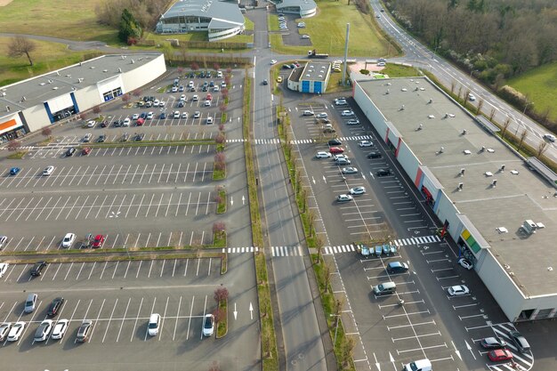 Luchtfoto van veel kleurrijke auto's geparkeerd op parkeerplaats met lijnen en markeringen voor parkeerplaatsen en richtingen