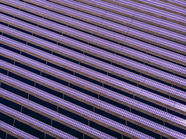 Luchtfoto van veel panelen van zonnecellen op een rij op het bovenaanzicht om nieuwe heldere energie te creëren. De toekomst is hier