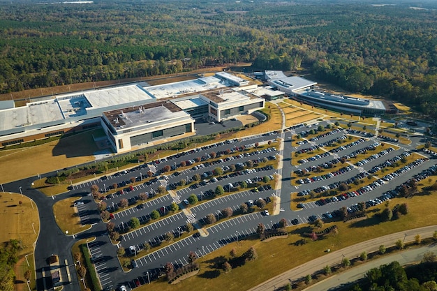 Luchtfoto van veel werknemersauto's geparkeerd op de parkeerplaats voor het industriële fabrieksgebouw