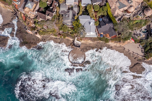 Luchtfoto van Victoria Beach met de beroemde piratentoren, een gebied van Orange County, Californië voor de rijken en welgestelden, toont de beukende golven en ze rollen over grillige kustlijnriffen
