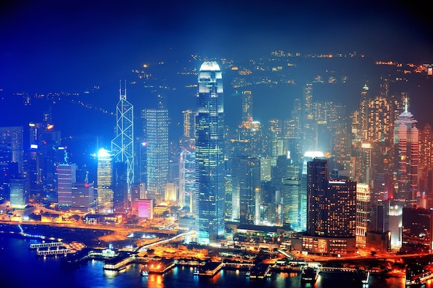 Luchtfoto van victoria harbour met de skyline van hong kong en stedelijke wolkenkrabbers 's nachts.
