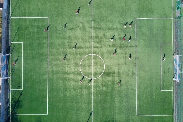 Luchtfoto van voetballers die voetbal spelen op het groene sportstadion.