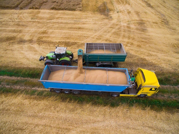 Luchtfoto van vrachtwagen die tarwe uit het veld oppikt